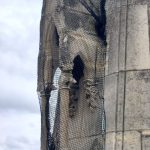 Debris netting on gothic church loose masonry